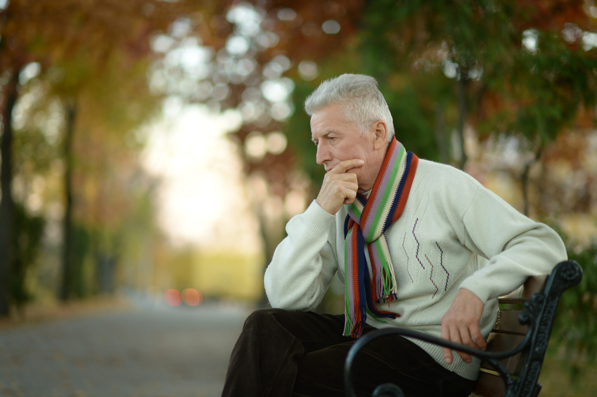 Man contemplating on park bench