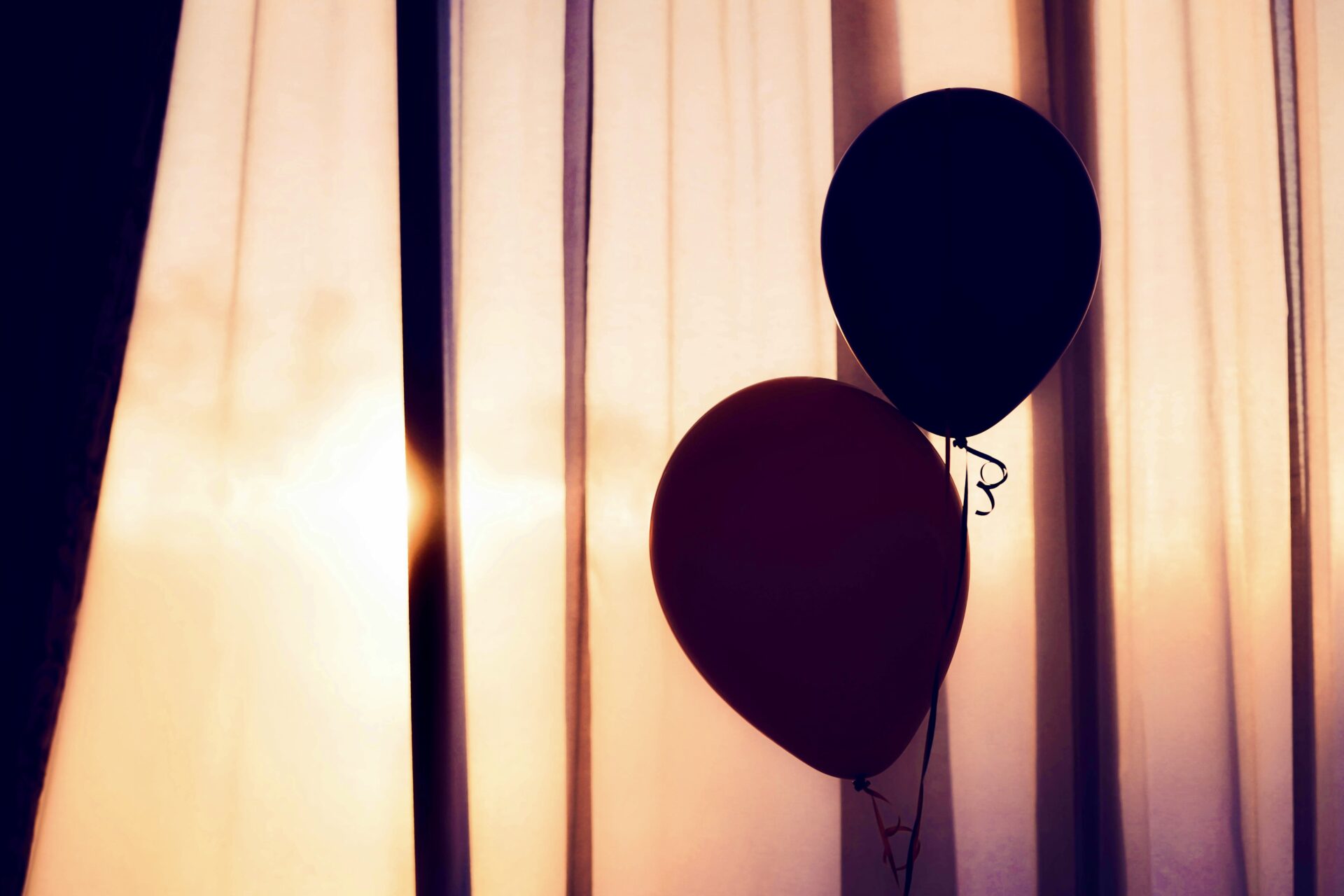 Balloons in room near curtain