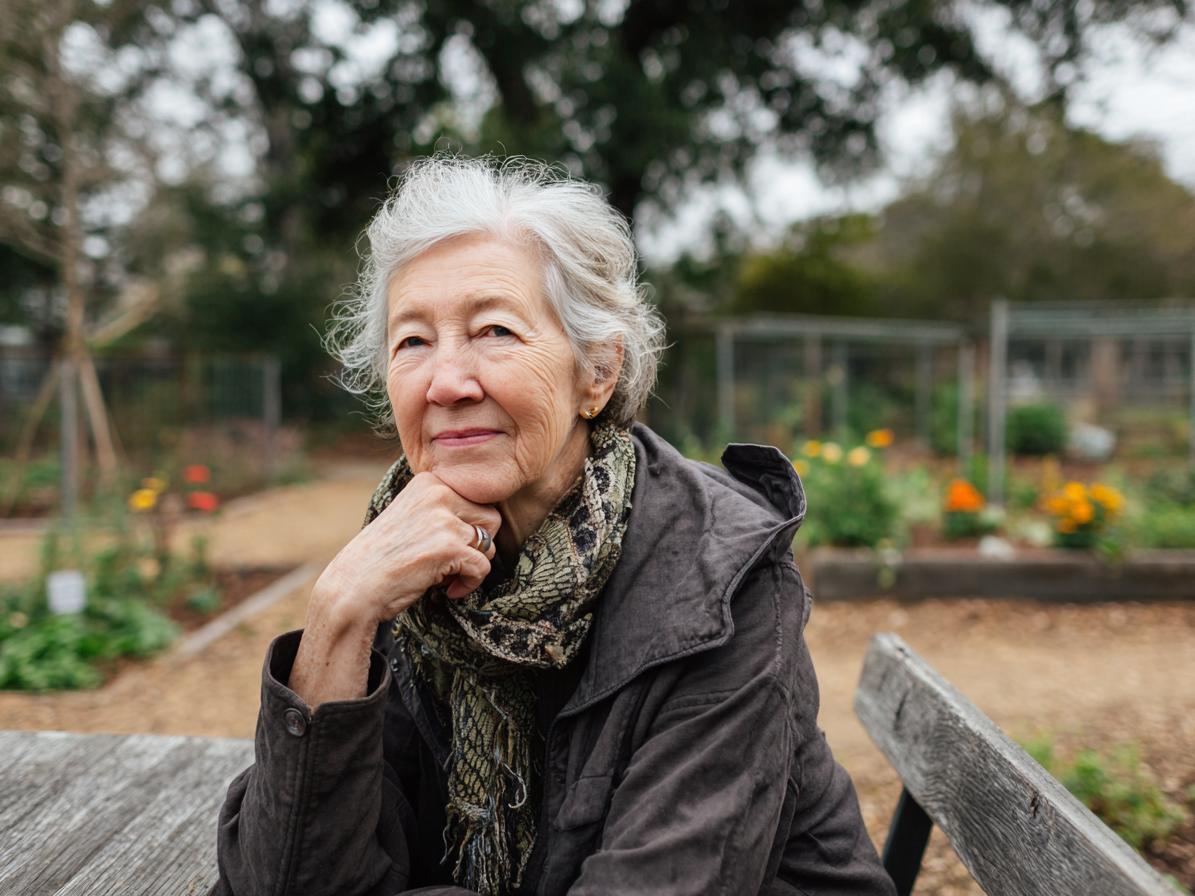 Woman sitting in allottment looking into camera